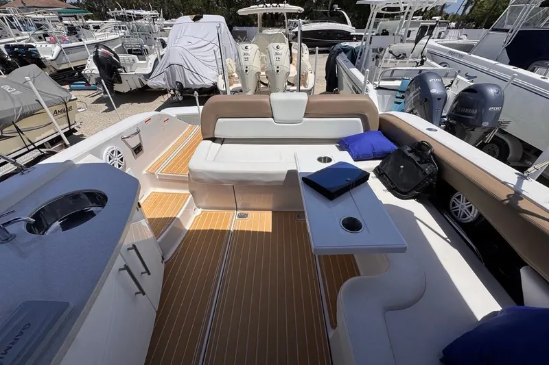 Slide: The Image of 2015 Four Winns H290 boat interior with seating, table, and marine equipment. - 63
