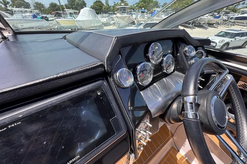 Slide: The Image of 2015 Four Winns H290 dashboard with gauges and steering wheel, featuring Garmin navigation system. - 66