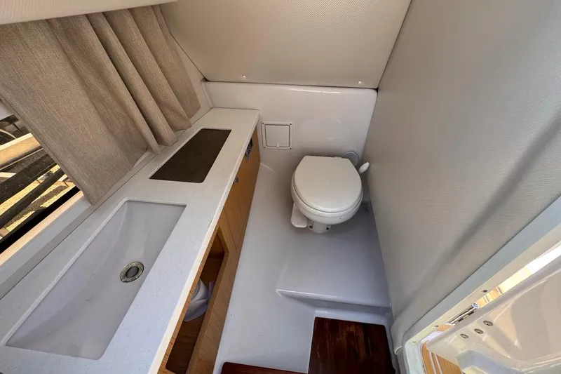 Slide: The Image of 2015 Four Winns H290 boat bathroom with sink, toilet, and countertop. - 68