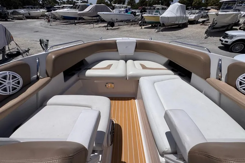 Slide: The Image of 2015 Four Winns H290 boat interior with cushioned seating and wood flooring. - 73