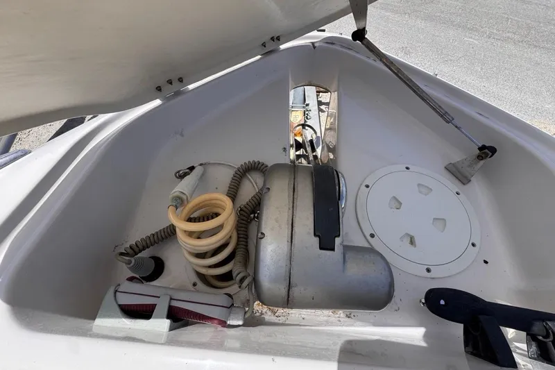Slide: The Image of 2015 Four Winns H290 boat anchor compartment with coiled hose and winch. - 76