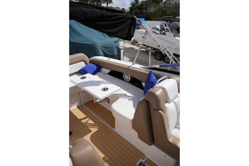 Slide: The Image of 2015 Four Winns H290 boat interior with seating, table, and blue cushions. - 8