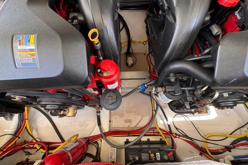 Slide: The Image of Engine compartment of a 2015 Four Winns H290 boat, showcasing mechanical components and wiring. - 82