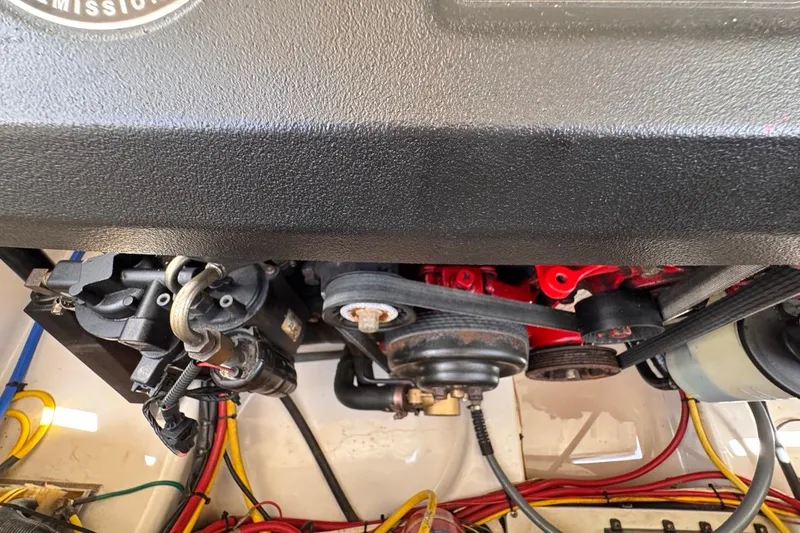 Slide: The Image of Engine compartment of a 2015 Four Winns H290 boat, showcasing belts and wiring. - 87