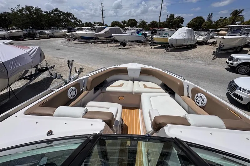 Slide: The Image of 2015 Four Winns H290 boat with spacious seating, parked in a marina. - 93