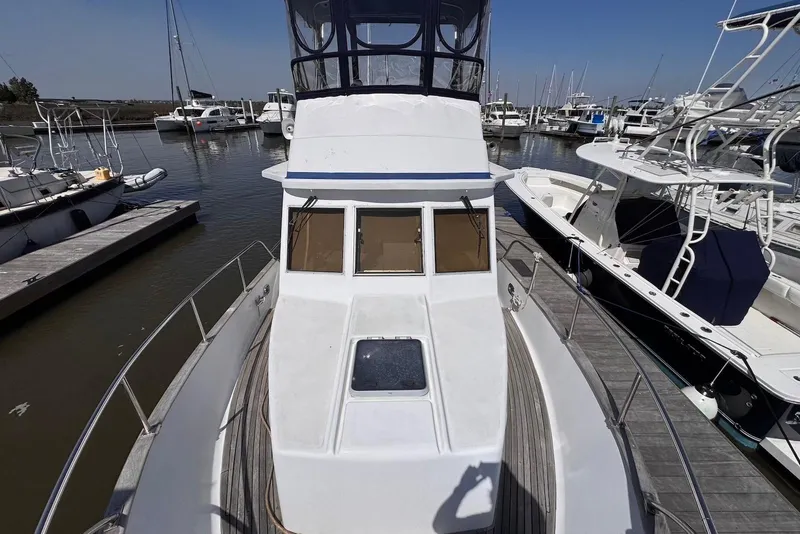 Slide: The Image of 1995 Island Gypsy Eurosedan 32 docked at marina, surrounded by other boats. - 11