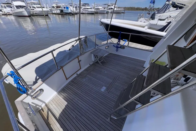 Slide: The Image of 1995 Island Gypsy Eurosedan 32 yacht deck with wooden flooring, docked at marina. - 13