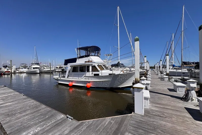 Slide: The Image of 1995 Island Gypsy Eurosedan 32 docked at a marina under clear blue skies. - 2