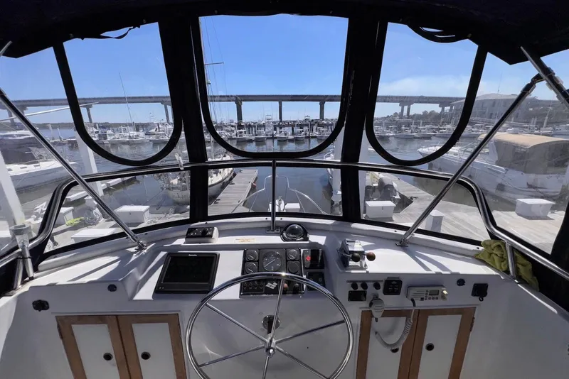 Slide: The Image of Interior view of 1995 Island Gypsy Eurosedan 32 yacht cockpit with marina backdrop. - 24