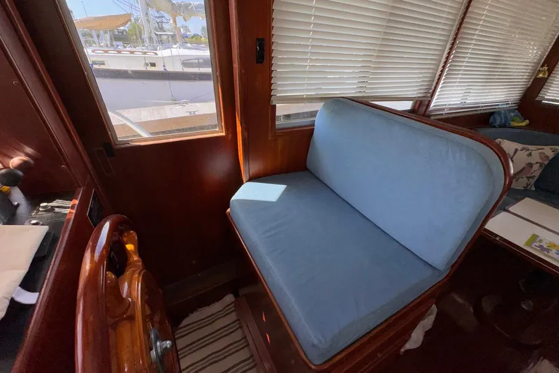 Slide: The Image of Interior of 1995 Island Gypsy Eurosedan 32 with blue cushioned seating and wooden accents. - 32