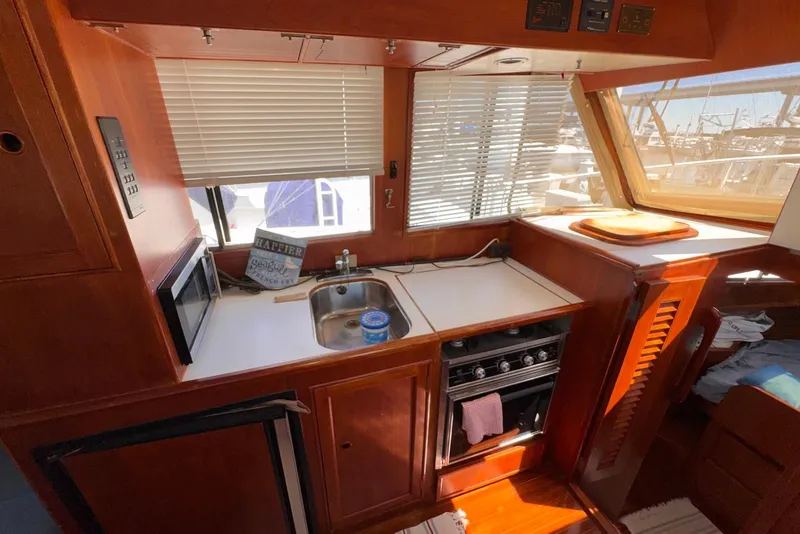 Slide: The Image of 1995 Island Gypsy Eurosedan 32 boat kitchen with sink, stove, and microwave. - 37