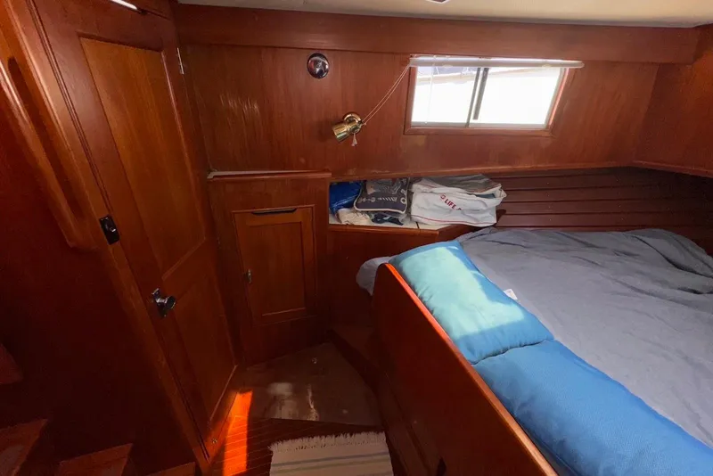 Slide: The Image of Cozy cabin interior of 1995 Island Gypsy Eurosedan 32 with wooden paneling and bedding. - 43