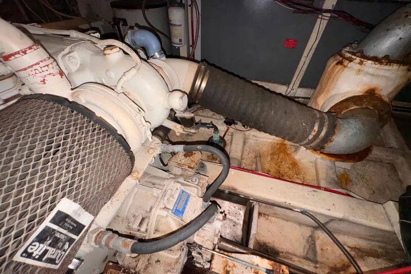 Slide: The Image of Engine compartment of a 1995 Island Gypsy Eurosedan 32, showing mechanical components and hoses. - 57