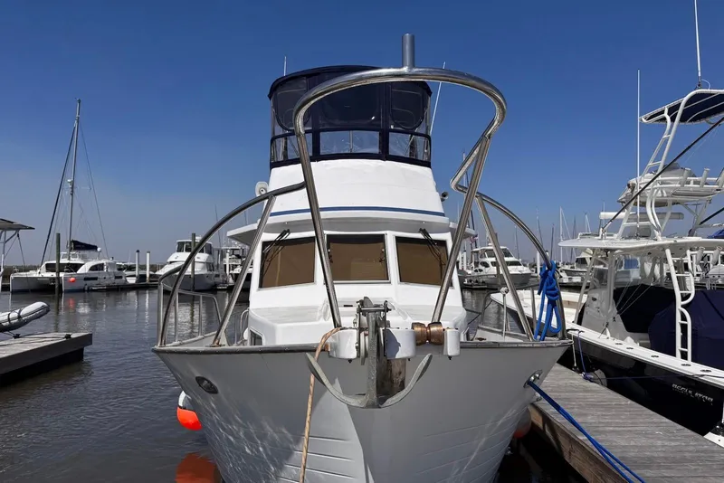 Slide: The Image of 1995 Island Gypsy Eurosedan 32 docked at marina, clear blue sky background. - 6