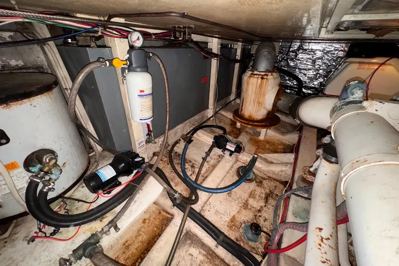 Slide: The Image of Engine room of a 1995 Island Gypsy Eurosedan 32 with visible pipes and equipment. - 61