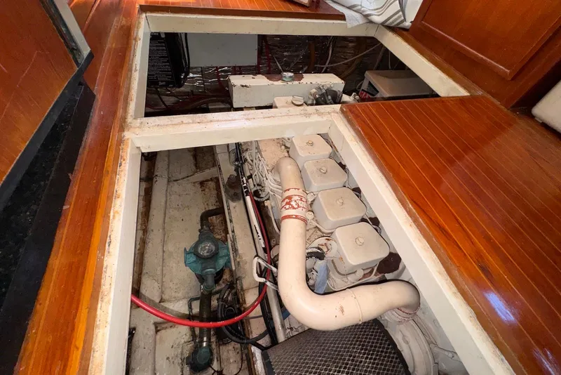 Slide: The Image of Engine room of a 1995 Island Gypsy Eurosedan 32 with visible components and wooden flooring. - 63