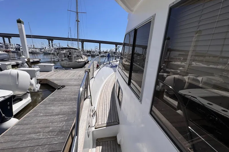 Slide: The Image of 1995 Island Gypsy Eurosedan 32 docked at marina, showcasing sleek design and wooden deck. - 8