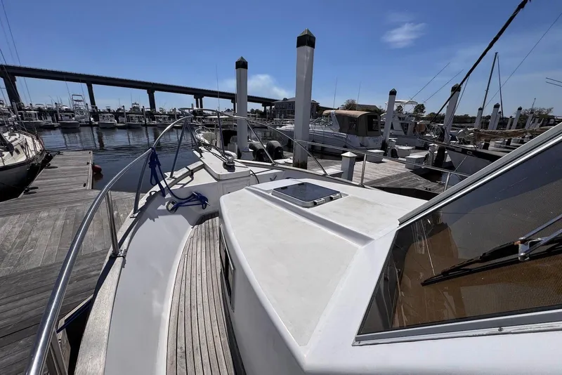 Slide: The Image of 1995 Island Gypsy Eurosedan 32 docked at a marina under a clear blue sky. - 9
