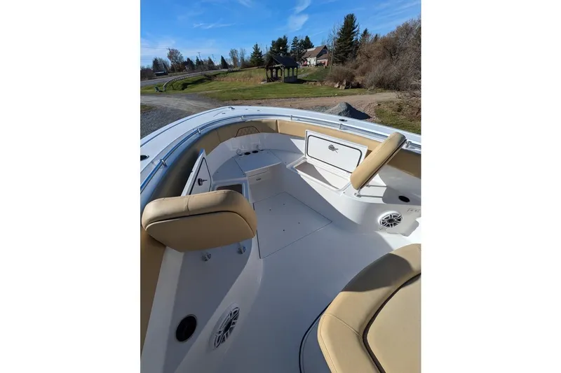 Slide: The Image of 2025 Sportsman Open 282 Center Console boat interior with tan seating and storage compartments. - 11