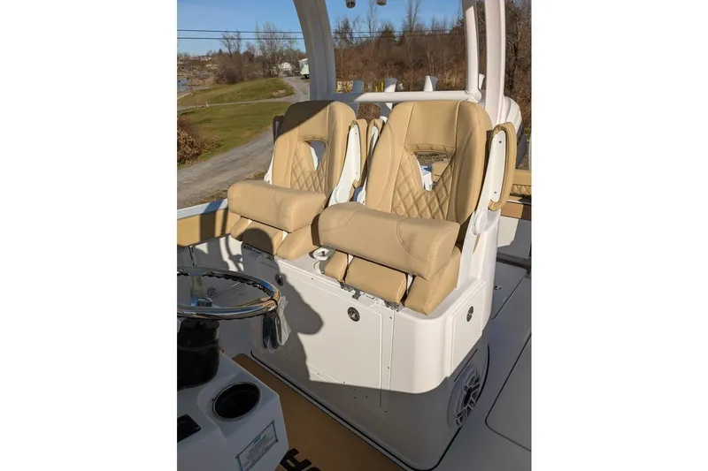 Slide: The Image of 2025 Sportsman Open 282 Center Console with tan cushioned seats and steering wheel. - 16