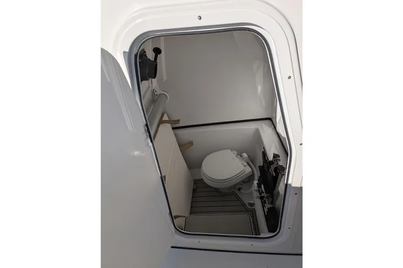 Slide: The Image of 2025 Sportsman Open 282 Center Console boat interior with compact marine toilet. - 9