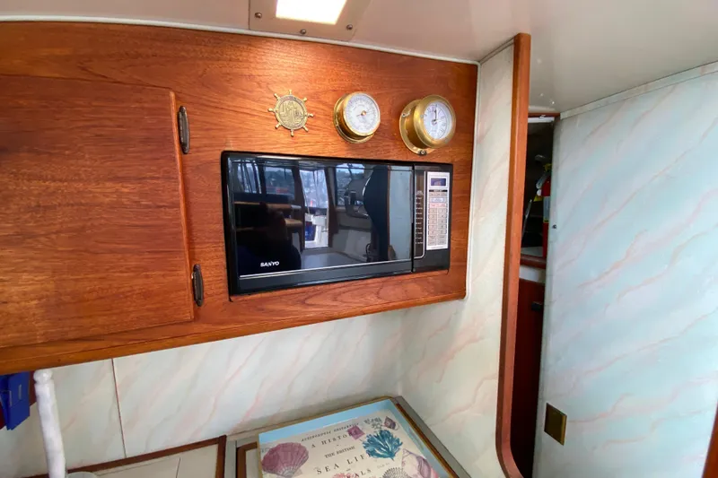 Slide: The Image of 1989 Bayliner 3288 Motoryacht interior with microwave and nautical instruments. - 12