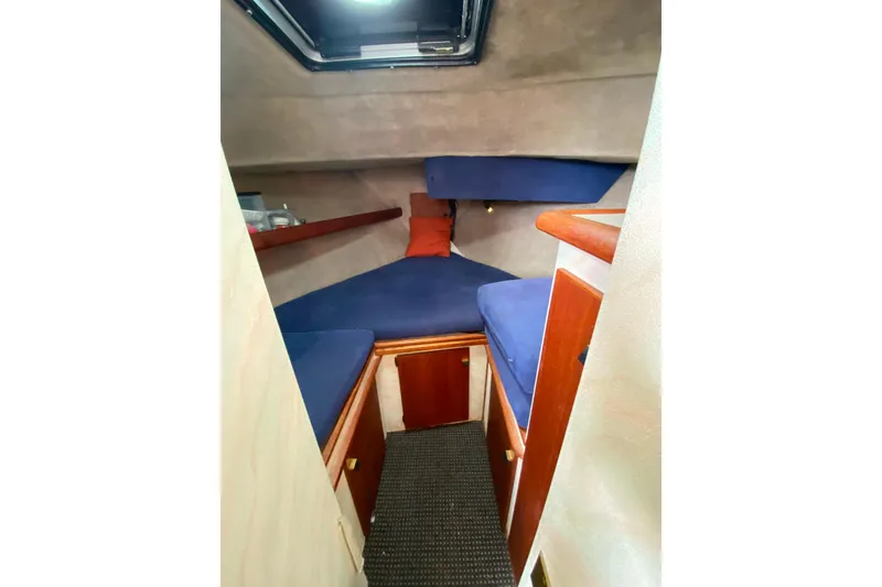 Slide: The Image of Interior cabin of 1989 Bayliner 3288 Motoryacht with blue cushions and wooden accents. - 13