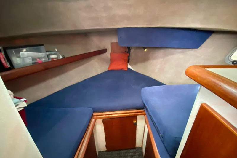 Slide: The Image of 1989 Bayliner 3288 Motoryacht cabin with blue cushions and wooden accents. - 14