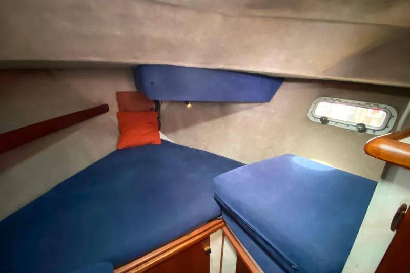 Slide: The Image of 1989 Bayliner 3288 Motoryacht cabin with blue bedding and small window. - 15