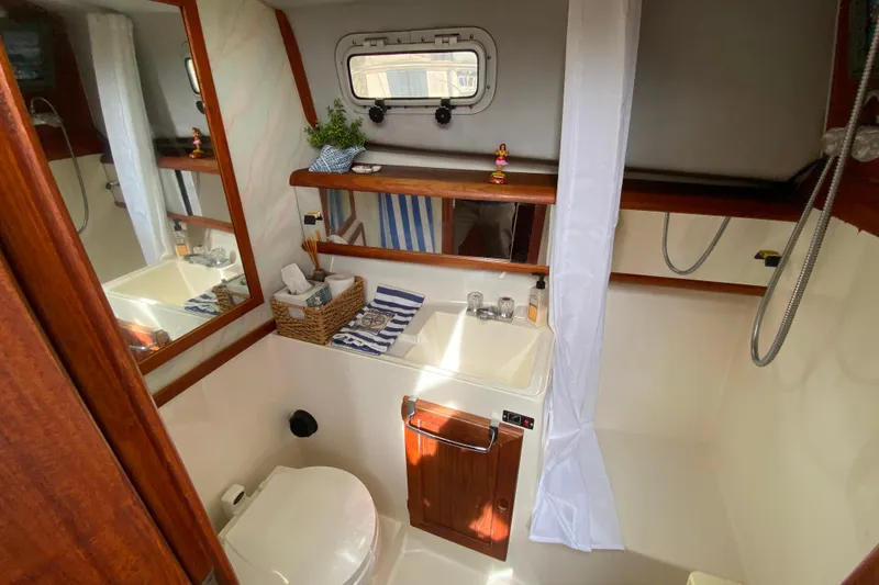 Slide: The Image of 1989 Bayliner 3288 Motoryacht bathroom with sink, toilet, and shower curtain. - 16