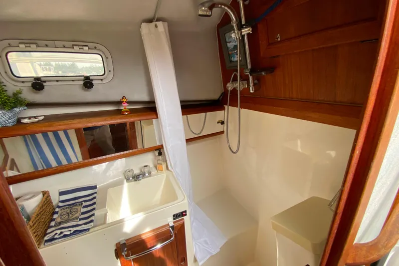 Slide: The Image of 1989 Bayliner 3288 Motoryacht bathroom with shower, sink, and wooden accents. - 18