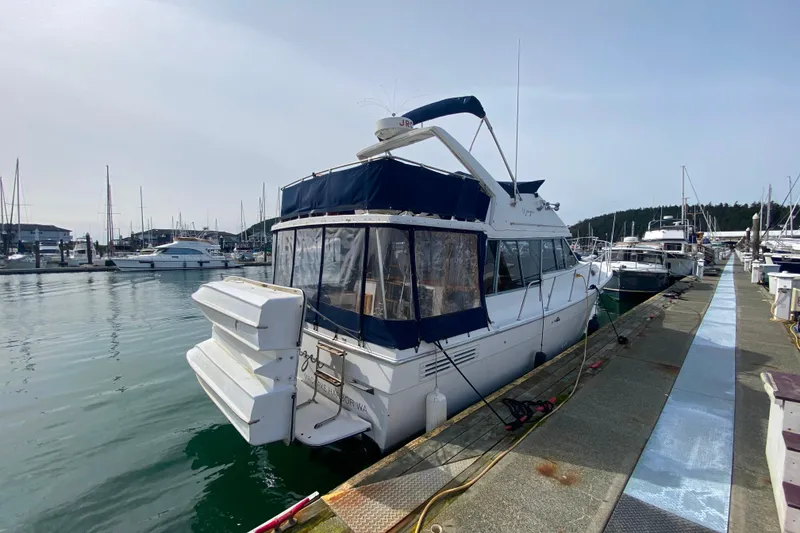 Slide: The Image of 1989 Bayliner 3288 Motoryacht docked at a marina, surrounded by other boats. - 2