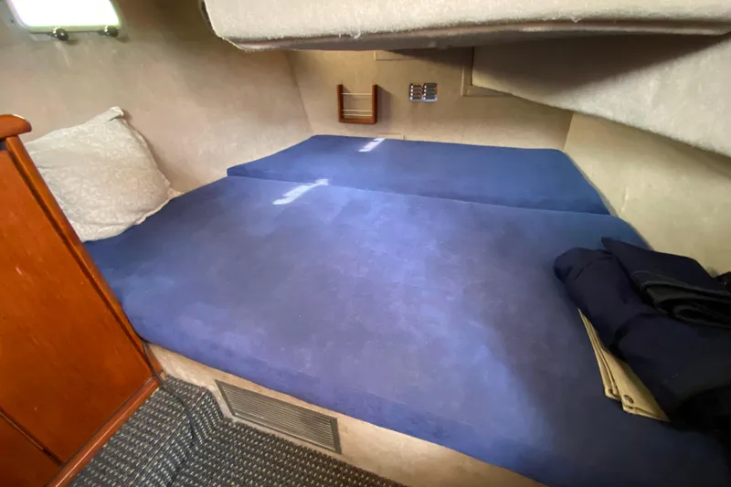 Slide: The Image of Interior cabin of 1989 Bayliner 3288 Motoryacht with blue bedding and wooden accents. - 21