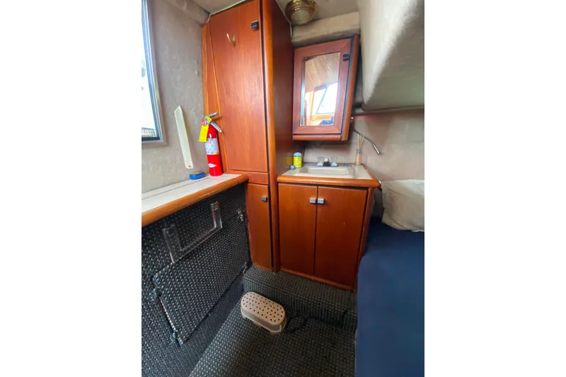 Slide: The Image of 1989 Bayliner 3288 Motoryacht interior with wooden cabinets, sink, and fire extinguisher. - 22