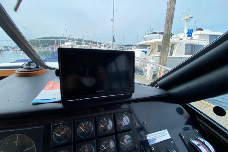 Slide: The Image of Interior view of 1989 Bayliner 3288 Motoryacht dashboard with Garmin GPS and marina background. - 27