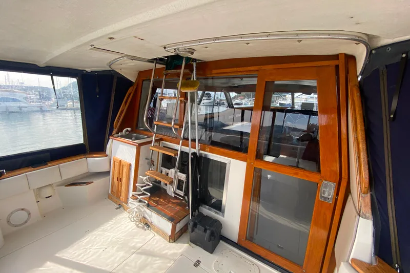 Slide: The Image of 1989 Bayliner 3288 Motoryacht interior with wooden accents and marina view. - 30