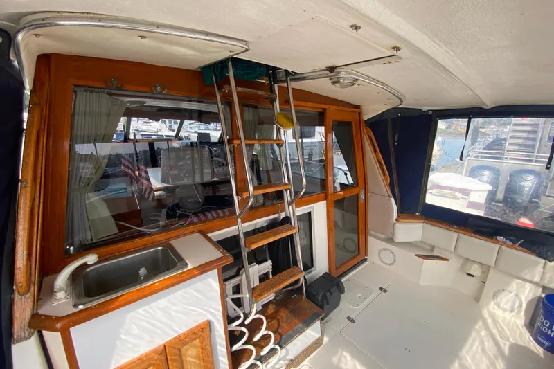 Slide: The Image of 1989 Bayliner 3288 Motoryacht interior with ladder, sink, and seating area. - 31