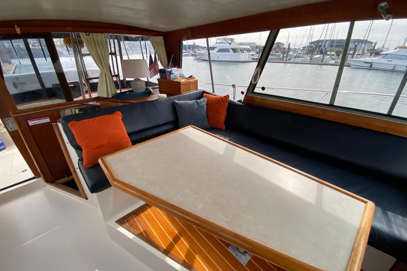 Slide: The Image of Interior of 1989 Bayliner 3288 Motoryacht with seating, table, and marina view. - 4