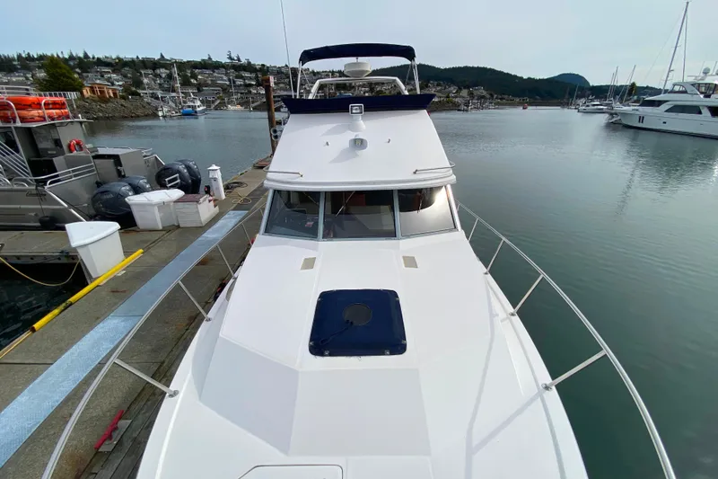 Slide: The Image of 1989 Bayliner 3288 Motoryacht docked in a serene marina setting. - 42