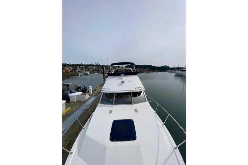 Slide: The Image of 1989 Bayliner 3288 Motoryacht docked in a serene marina setting. - 44