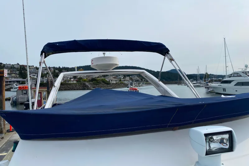 Slide: The Image of 1989 Bayliner 3288 Motoryacht docked, featuring blue canopy and radar, in a marina setting. - 45