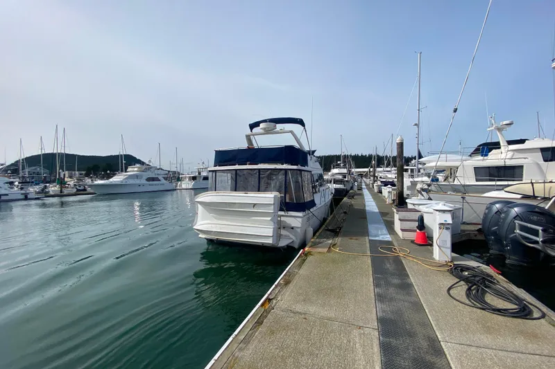Slide: The Image of 1989 Bayliner 3288 Motoryacht docked at a marina, surrounded by other boats. - 47