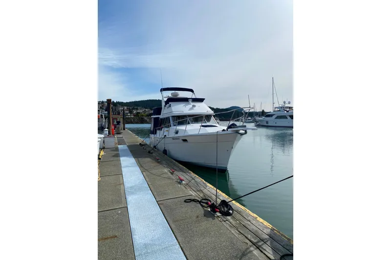Slide: The Image of 1989 Bayliner 3288 Motoryacht docked at marina, calm waters, clear sky. - 49