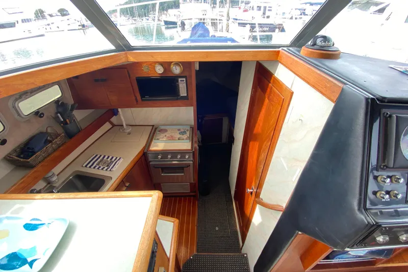 Slide: The Image of 1989 Bayliner 3288 Motoryacht interior with kitchen, stove, and wooden cabinetry. - 5