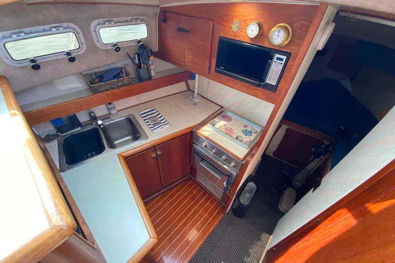 Slide: The Image of 1989 Bayliner 3288 Motoryacht kitchen with wooden cabinetry, sink, and microwave. - 6