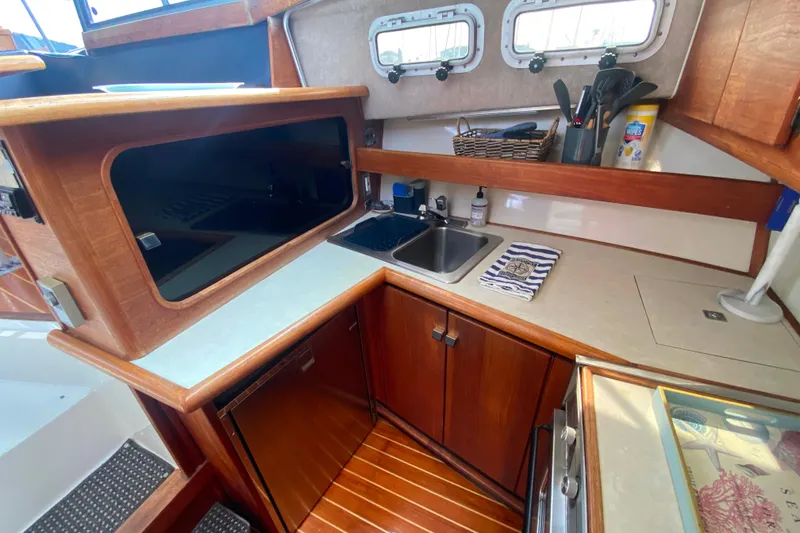Slide: The Image of 1989 Bayliner 3288 Motoryacht kitchen with wooden cabinetry, sink, and appliances. - 7