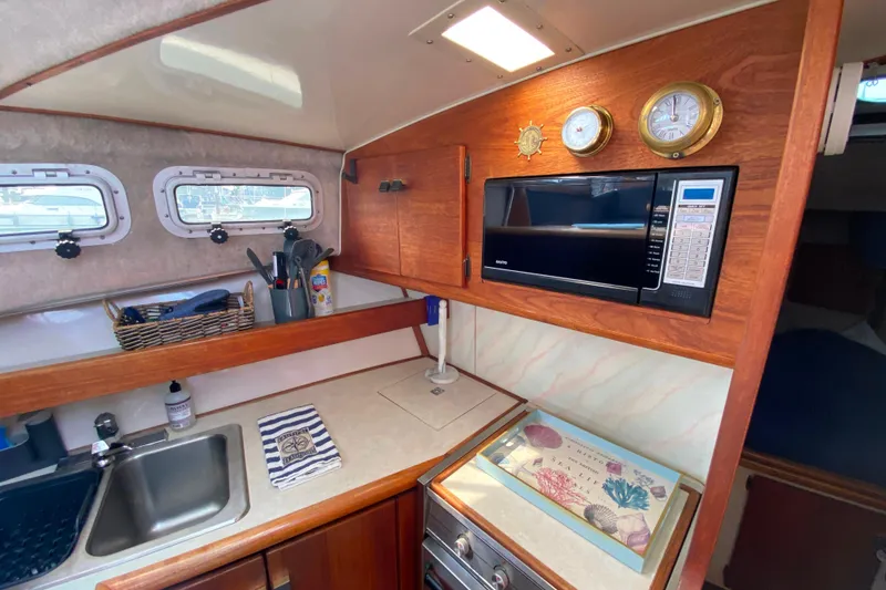 Slide: The Image of Interior of 1989 Bayliner 3288 Motoryacht kitchen with microwave, sink, and nautical decor. - 8