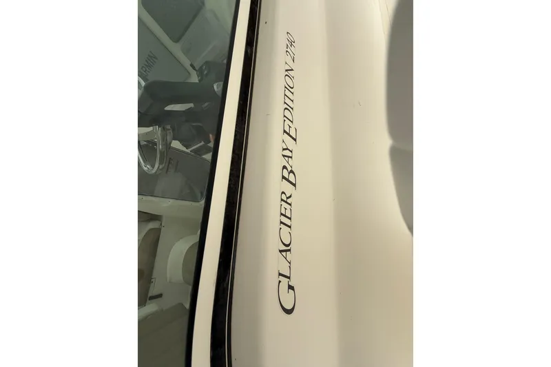 Slide: The Image of 2019 World Cat Glacier Bay Edition 2740 Dual Console boat, close-up of model name on hull. - 19
