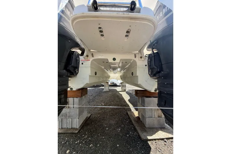 Slide: The Image of 2019 World Cat Glacier Bay Edition 2740 Dual Console boat on blocks, underside view. - 21