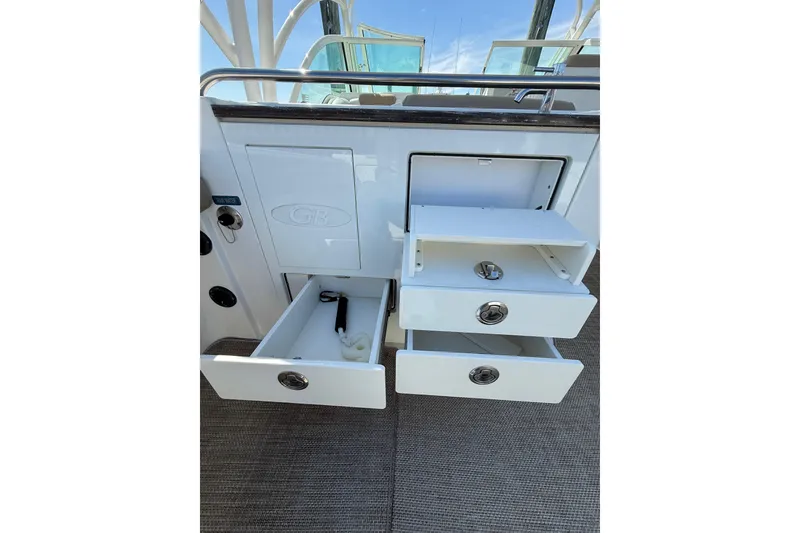 Slide: The Image of 2019 World Cat Glacier Bay Edition 2740 Dual Console storage drawers open on deck. - 27